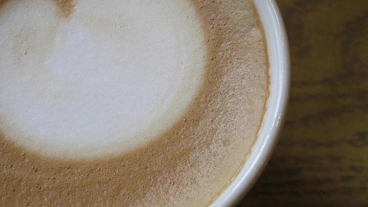 Thick microfoam topping a fresh cappuccino in a white cup