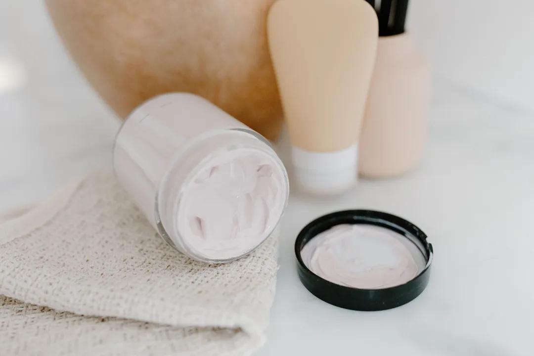 Open jar of rich white face cream showing smooth swirled texture